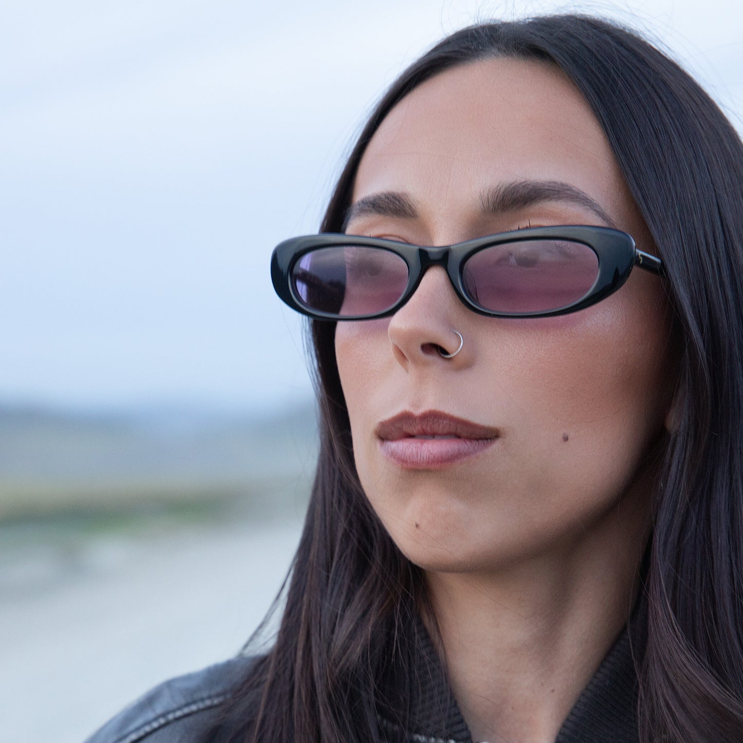 Woman wearing sunglasses with a blurred outdoor background